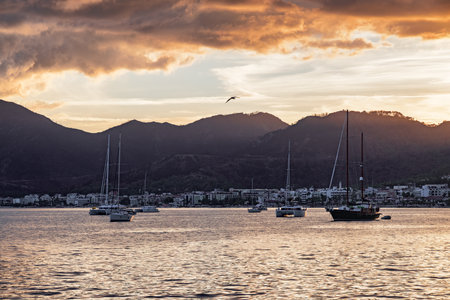 Sunset view of yachts crossing Marmaris Harbor, Turkey. The port city is a popular tourist destination in the Turkish Riviera.の写真素材