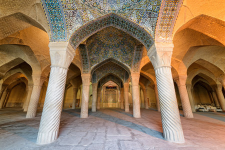Shiraz, Iran - 31 October, 2018: Awesome view of prayer hall in the Vakil Mosque. Colorful mosaic on vaulted ceiling and carved columns of hypostyle hall. Persian interior of the Muslim place.のeditorial素材