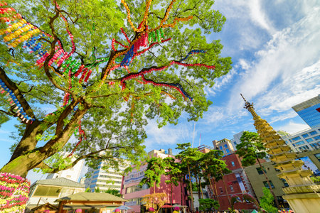 Seoul, South Korea - October 15, 2017: Awesome colorful view of green tree decorated with paper lanterns and flowers in garden of Jogyesa Temple. Jogyesa Temple is a symbol of Korean Buddhism.のeditorial素材