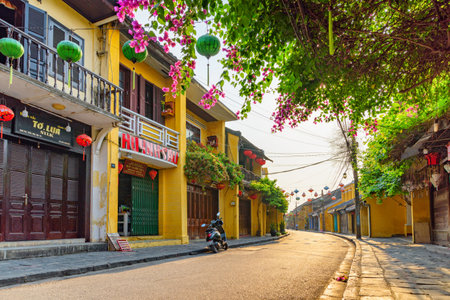 Hoi An (Hoian), Vietnam - April 12, 2018: Unusual morning view of deserted street decorated with colorful silk lanterns. Scenic traditional old yellow houses of Hoi An Ancient Town.のeditorial素材