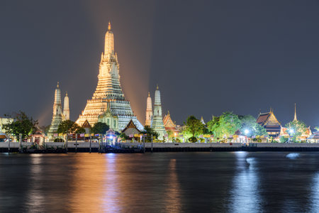 Awesome night view of Wat Arun across the Chao Phraya River in Bangkok, Thailand. The Buddhist temple is a landmark of Bangkok and a popular tourist attraction of Thailand.の写真素材