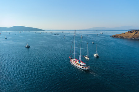 Aerial view of a white yacht crossing Bodrum Harbor. The port city is a popular tourist destination in the Turkish Riviera.の写真素材