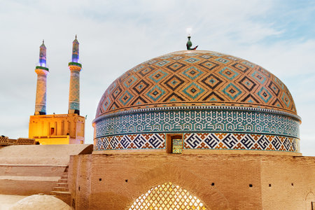 Amazing evening view of dome and minarets of the Jameh Mosque of Yazd, Iran. Azari style of Persian Islamic architecture. The ancient town is a popular tourist destination of the Middle East.の写真素材