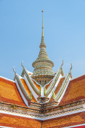 Awesome detail of roof of Wat Arun in Bangkok, Thailand. Amazing exterior of the temple. The Buddhist temple is a landmark of Bangkok and a popular tourist attraction of Thailand.の写真素材