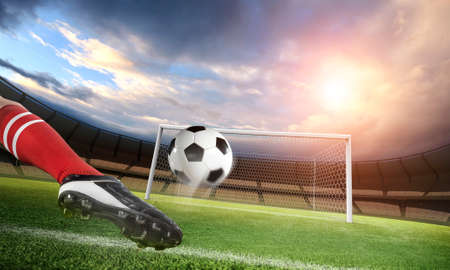 Football player kicks the ball on the stadium. The imaginary stadium is modelled and rendered.の写真素材