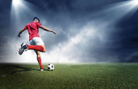 Football player, dark cloudy background. The imaginary stadium is modeled and rendered.の写真素材