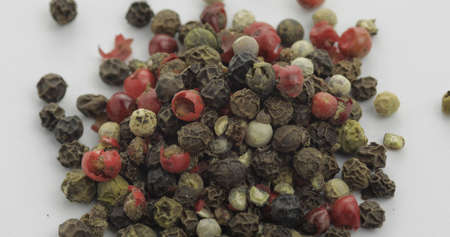 Mix of multicolored pepper. Peas with spices. Herbal spice, aromatic seasoning for food preparation and cooking, macro shot against a white backgroundの写真素材