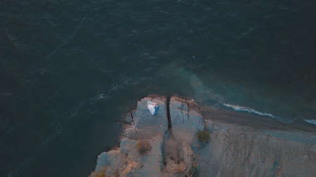 Wedding couple on a slope of the mountain hill near sea. Lovely groom and bride. Arial view. Shot from droneの写真素材