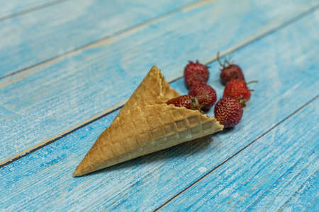 Berry season. Berry ice cream. Berries of strawberry in a waffle on a blue wooden background