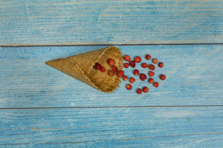 Berry season. Berry ice cream. Berries of strawberry in a waffle on a blue wooden background