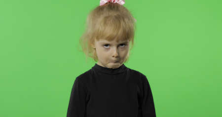 Pretty girl emotionally makes faces in black blouse. Portrait close up. Happy, cute little blonde child, 3-4 years old. Green screen. Chroma Keyの写真素材