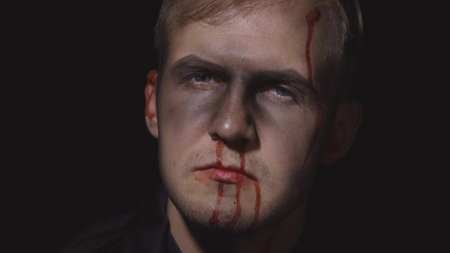 Halloween man portrait with head injury. Guy with dripping blood on his face. Executioner, Vampire...