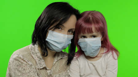 Sick mother embrace daughter in medical mask. Coronavirus concept. Young family quarantine. A virus...