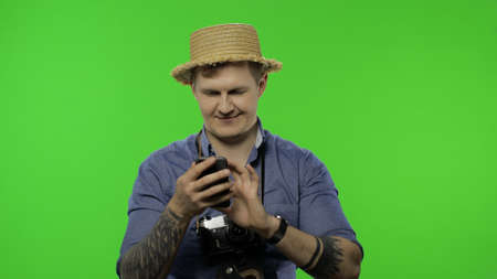 Portrait of man tourist using a smartphone, chatting, working. Handsome man in blue shirt and hat...