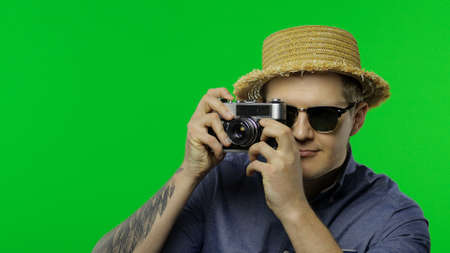 Portrait of man fashion tourist photographer is taking photos on retro camera. Handsome man on...