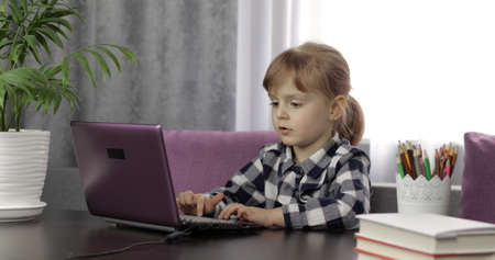 Online learning, distance education, lesson at home, technology for kids. Girl doing school program online homework with teacher, using digital laptop computer. Education during coronavirus quarantineの写真素材