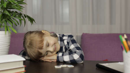 Child girl exhausted and sleeping after homework online video lessons at home. E-learning, webinar....