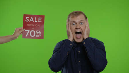 Inscription advertising Sale Now On Up To 70 Percent Off next to joyful man. Guy celebrating,...