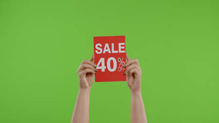 Sale 40 Percent Off advertisement inscription on paper sheet in womans hands on green screen. Holiday discounts, shopping with low prices on Black Friday. Chroma key background. 6k downscaleの写真素材