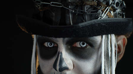 Close-up shot of creepy man in skeleton makeup. Guy opening his eyes and looking spooky at camera....