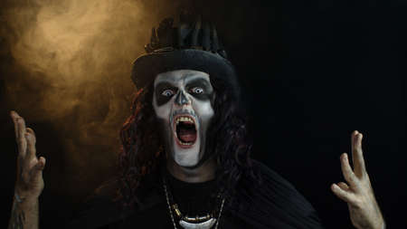Creepy man with skeleton makeup in top-hat. Guy turning his head and looking at camera, trying to...