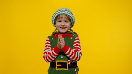 Sly kid teen girl steepls fingers and schemes something gets interesting idea how to decorate house, waiting for gift box. New Year and Christmas holidays winter time. Child Christmas elf Santa helperの写真素材