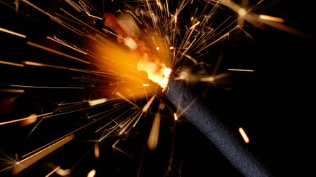 Close-up macro of burning sparklers bengal fire candle in front of black dark background. Sparkling lights at birthday party, wedding, New Year, Christmas Eve, Xmas Holidaysの写真素材