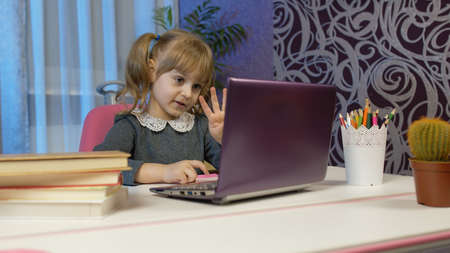 Child schoolgirl learns lessons teach mathematic and counting with teacher being at home using...