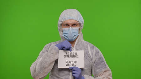 Medical worker doctor in PPE suit with text inscription slogan on paper