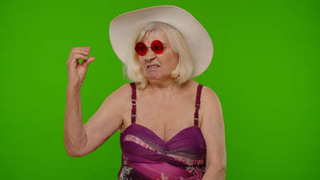 Senior grandmother tourist showing bla-bla-bla gesture, empty promises, blah, lier on chroma key