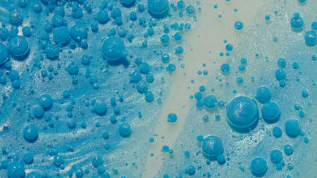 Top view movement of bright oil bubbles in slow motion. Multicolored surface background. Fantastic...