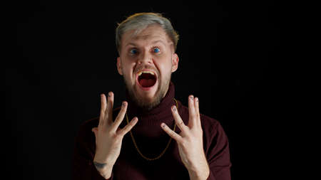 Stylish young man with blue eyes shout loudly, wins competition achieves goal, makes triumph...
