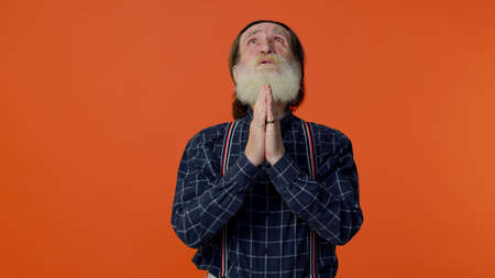 Please, God, forgive me. Mature old bearded man in praying, looking upward and making wish, asking...