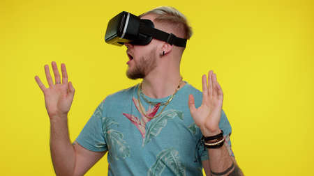 Amazed tourist adult man using headset helmet app to play simulation game. Watching virtual reality...