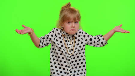No idea, I dont know answer. Puzzled clueless uncertain blonde kid child raising hands in helpless gesture, embarrassed confused by difficult question. Teenager children girl on chroma key backgroundの写真素材