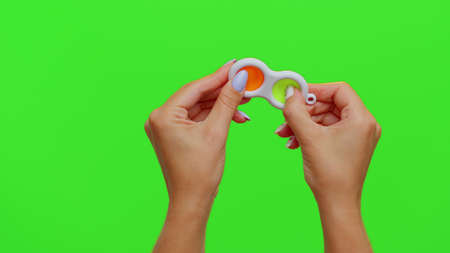 Hands holding silicone bubbles sensory toy simple dimple isolated on chroma key background.