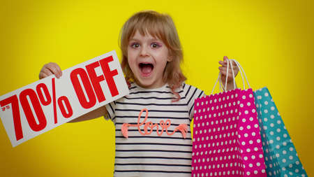 Blonde little teen kid child girl showing shopping bags and Up To 70 Percent Off inscriptions banner...