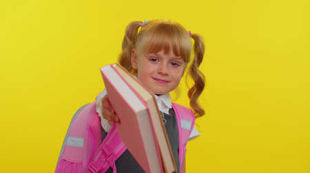 Happy pretty happy kid primary school girl with ponytails wearing uniform smiling grimacing looking...