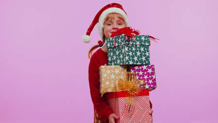 Girl in Christmas red sweater hat looking surprised at mount of boxes hands, excited by so many...
