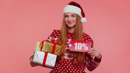 Happy girl in red New Year sweater showing gift box and 10 Percent discount inscriptions banner...