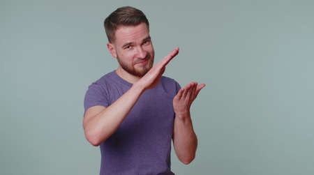 Cheerful rich man in purple t-shirt showing wasting or throwing money around hand gesture, more tips...