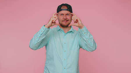 Photographer man gesturing picture frame with hands, looks through fingers and focusing on...