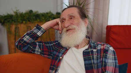 Close-up of happy calm senior old grandfather man pensioner smiling friendly, glad expression...