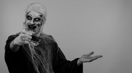 Creepy man with bloody scars face, Halloween stylish zombie make-up. Scary wounded undead guy...