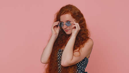Portrait of seductive cheerful stylish woman in dress wearing sunglasses, charming smile. People...