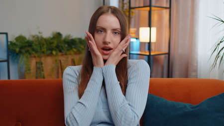 Oh my God, Wow. Young woman surprised looking at camera with big eyes, shocked by sudden victory,...