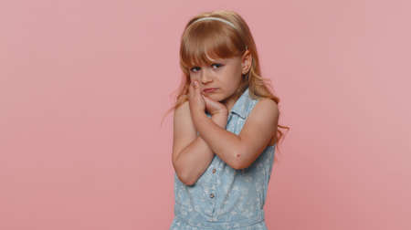 Dental problems. Young preteen child girl kid touching cheek, closing eyes with expression of...
