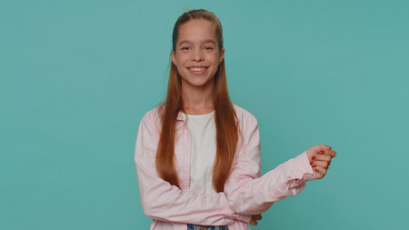 Portrait of happy lovely pretty teenager girl in pink shirt looking at camera, smiling. Young stylish female student child kid isolated alone on blue studio background indoors. Female nature beautyの写真素材