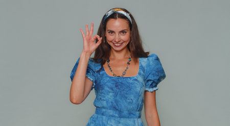 Ok. Lovely pretty young woman looking approvingly at camera showing ok gesture, like sign positive,...