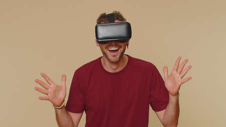 Bearded handsome young man using headset helmet app to play simulation drawing game. Watching...